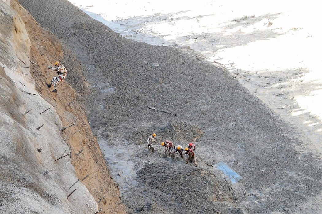 Indo Tibetan Border Police personnel work to clear Tapovan tunnel from debris following floods