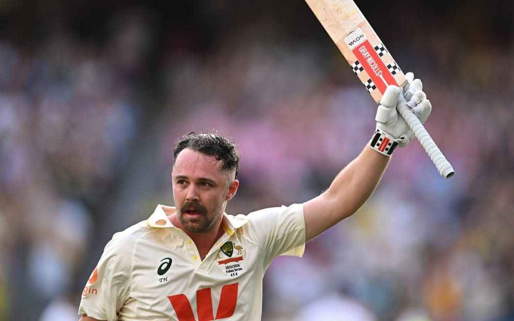 Australian batsman Travis Head reacts to the crowd applause as he leaves the field following his century to help Australia win the first Ashes Test, Perth, 2025.