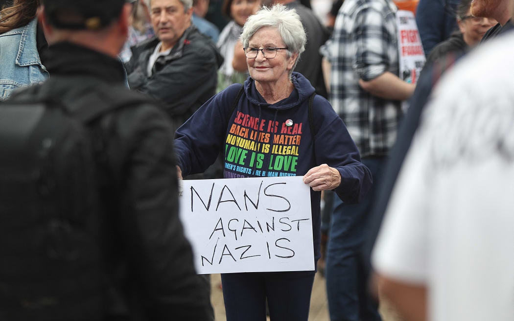 A protester defending the Abdullah Quilliam Mosque in Liverpool holds a placard holds a placard reading "Nans against Nazis" on 2 August, against the 'Enough is Enough' demonstration.