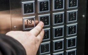 hand presses the button on the floor selection in the Elevator