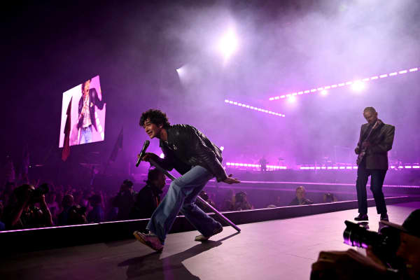 Matty Healy (L) lead singer of British band The 1975 performs on the Pyramid stage during the third day of the Glastonbury festival at Worthy Farm in the village of Pilton in Somerset, south-west England, on June 27, 2025.