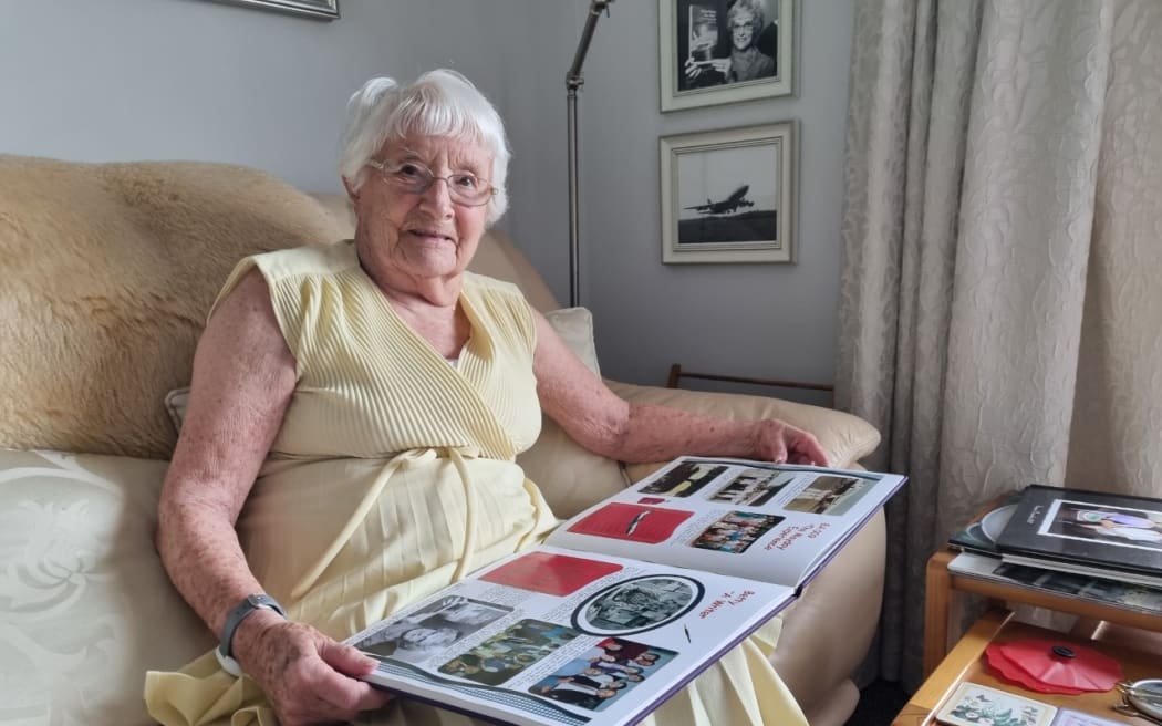 Betty Ferguson reads a page about the flight from her scrapbook.