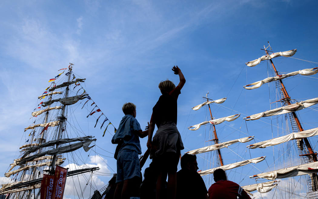 People gather to watch ships and boats sailing on the IJ River in a Sail-in Parade during the 50th edition of SAIL Amsterdam festival, in Amsterdam on August 20, 2025. (Photo by Ramon van Flymen / ANP / AFP) / Netherlands OUT / NETHERLANDS OUT / NETHERLANDS OUT