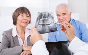 A dentist showing an x-ray to an older couple