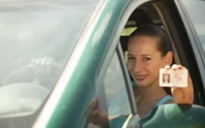 woman in car holding driver licence