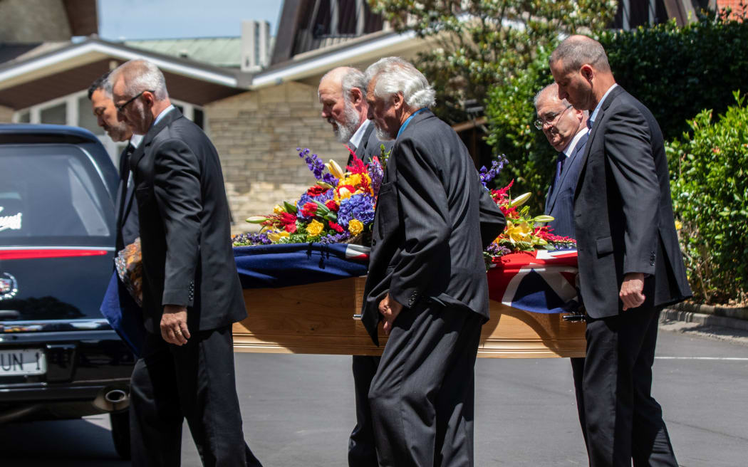 Mike Moore's casket is carried into his funeral service in Auckland.