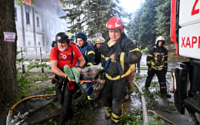 Rescuers carry a wounded person out of the ruins of a civilian plant following Russian powerful attacks on the Ukrainian city of Kharkiv early on June 7, 2025, amid the Russian invasion of Ukraine. Russia unleashed a barrage of missiles, drones and bombs across Ukraine early on June 7, killing at least five people in a major attack that the mayor of Kharkiv, Ukraine's second largest city, described as unprecedented. (Photo by SERGEY BOBOK / AFP)