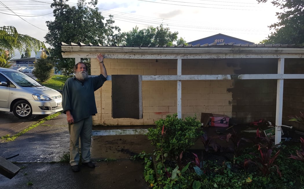 New Lynn resident Rodney Johnson points out how high the floodwaters reached at their peak.