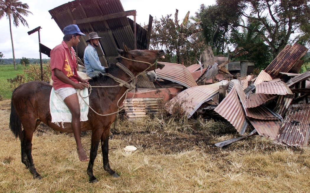 Two Fijian-Indian farmers inspect the burnt out house of a fellow farmer at Muaniweni district near Suva, 02 August 2000, as ethnic violence continues.  Ethnic-Indian farmers around the country are still being terrorised by Fijian supporters of coup leader George Speight who is imprisoned on the island of Nukulau and awaiting his day in court.  (ELECTRONIC IMAGE)  AFP PHOTO William WEST (Photo by WILLIAM WEST / AFP)