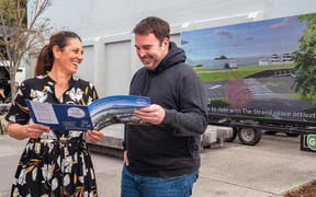 Whakatāne District Council senior policy planner Deb Ganley chats with Whakatāne Online Retailers page creator Jason Lougher, the two have been discussing the local retailers’ response to the council’s consultation document. A large screen showing potential ideas for the CBD is in the background.