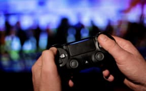 A gamer uses a PS4 controller as he plays at the new Ubisoft video game "Watch Dogs Legion"
