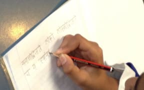 A child writing Sanskrit at Ficino School.