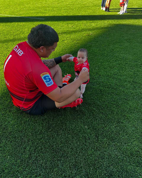 All Black Tamaiti Williams plays with daughter Kaea on the rugby field.