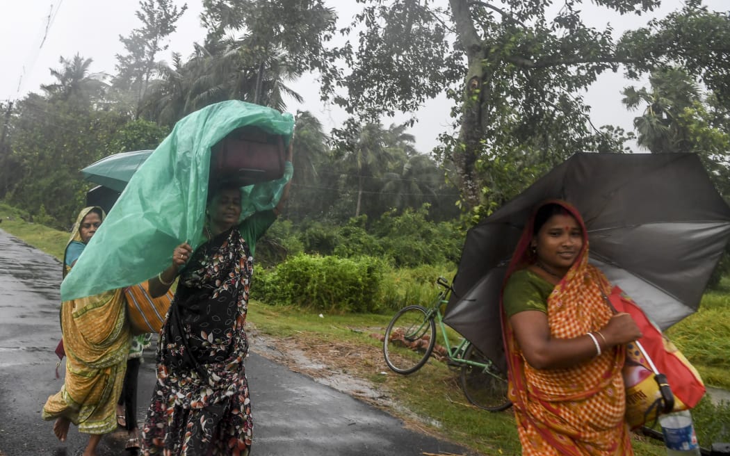 Villagers holding umbrellas carry their belongings on their way to enter a relief centre as Cyclone Bulbul is approaching, in Bakkhali near Namkhana in Indian state of West Bengal on November 9, 2019.