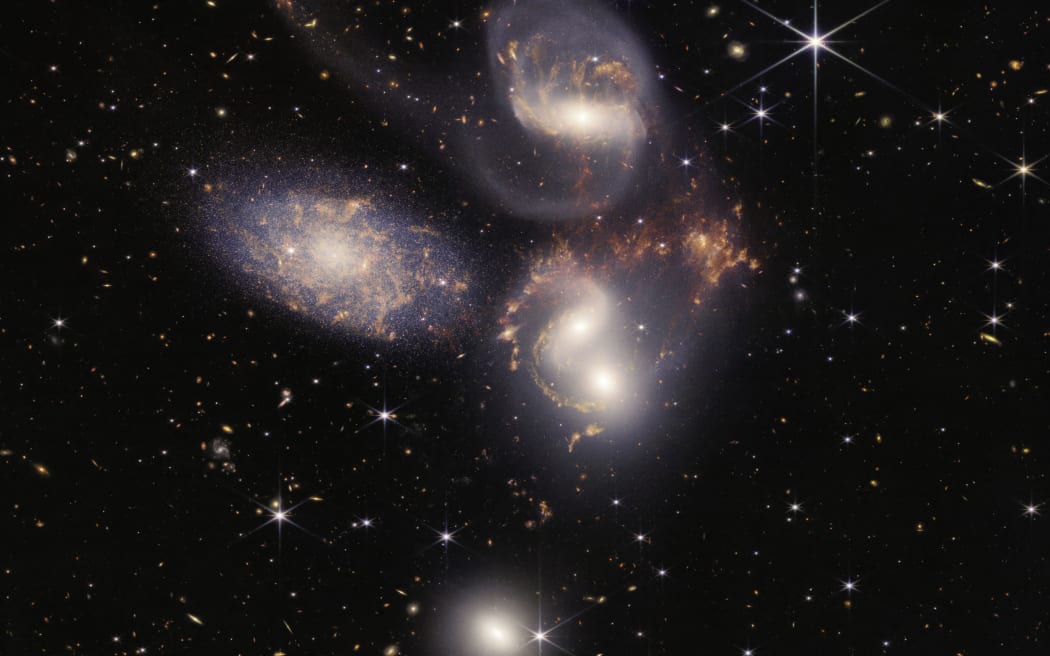 This image released by NASA on July 12, 2022, shows Stephan’s Quintet captured by the James Webb Space Telescope (JWST), a visual grouping of five galaxies, in a new light. This enormous mosaic is JWST’s largest image to date, covering about one-fifth of the Moon’s diameter. It contains over 150 million pixels and is constructed from almost 1,000 separate image files. - The JWST is the most powerful telescope launched into space and it reached its final orbit around the sun, approximately 930,000 miles from Earths orbit, in January, 2022. The technological improvements of the JWST and distance from the sun will allow scientists to see much deeper into our universe with greater detail. (Photo by Handout / NASA / AFP) / RESTRICTED TO EDITORIAL USE - MANDATORY CREDIT "AFP PHOTO / NASA" - NO MARKETING NO ADVERTISING CAMPAIGNS - DISTRIBUTED AS A SERVICE TO CLIENTS