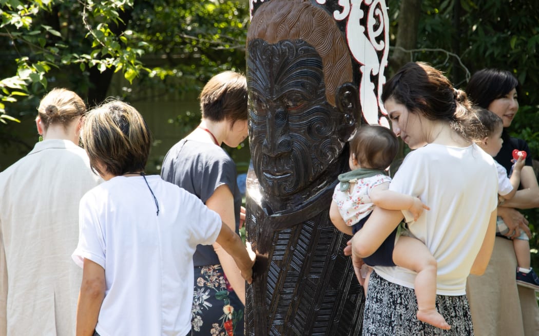 Visitors examine the carvings on a new ceremonial doorway at the New Zealand Embassy in Tokyo.