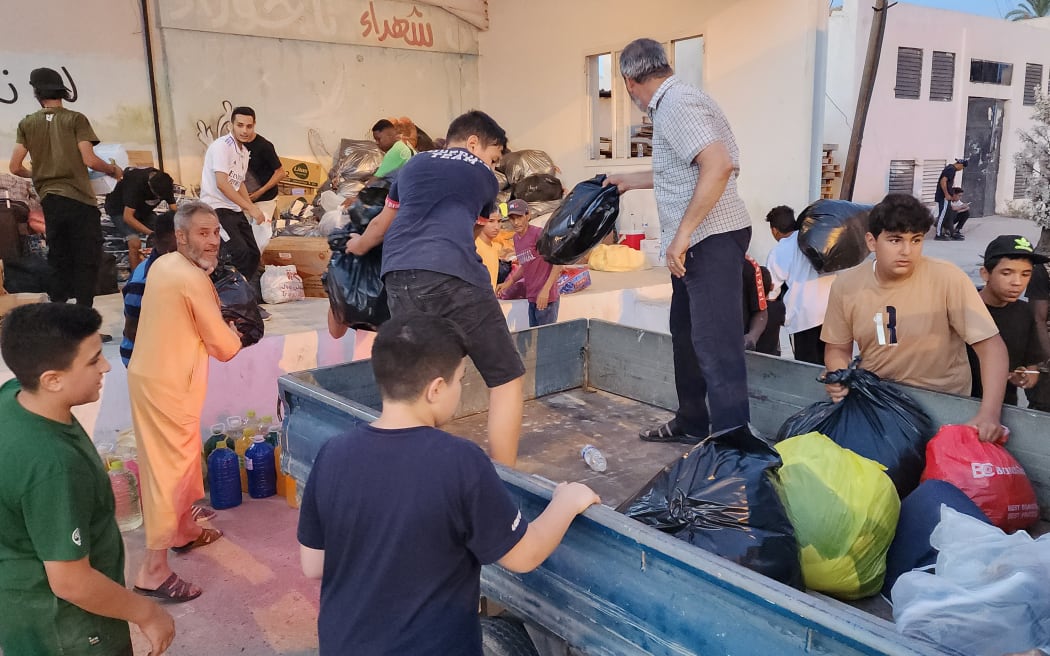 People bring donated supplies to a collection point in Libya's capital Tripoli on 15 September, before their transfer to areas affected by the floods.