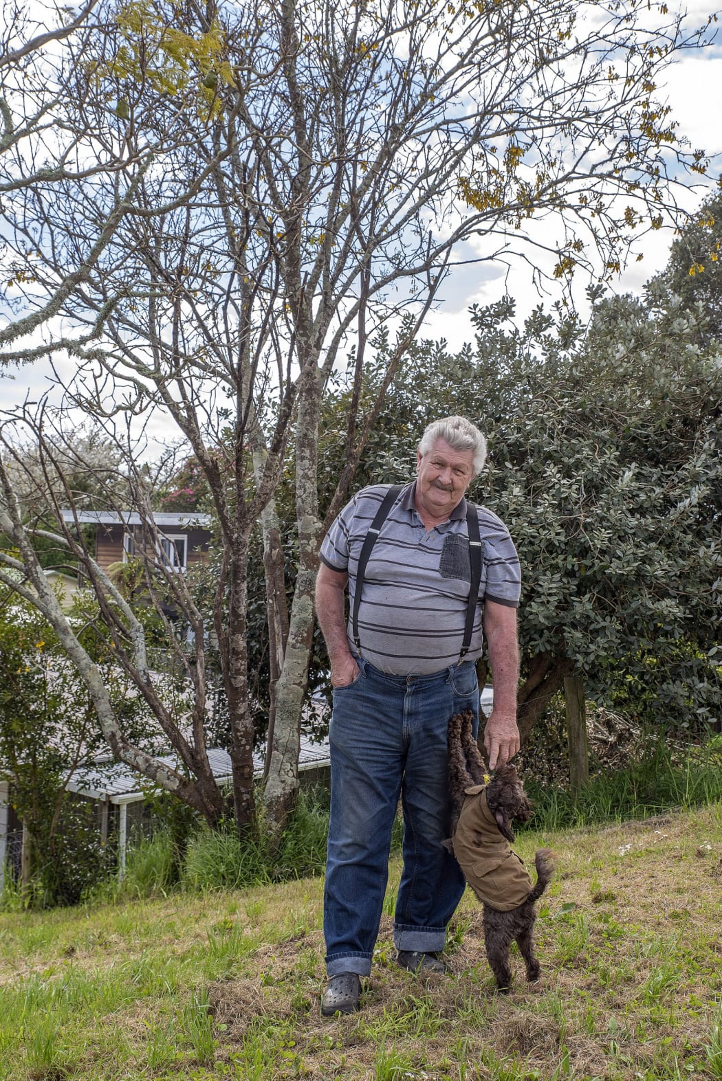 Riverside Drive resident Don Meads and dog Banjo near the kōwhai tree planted on the stopbank behind his house.