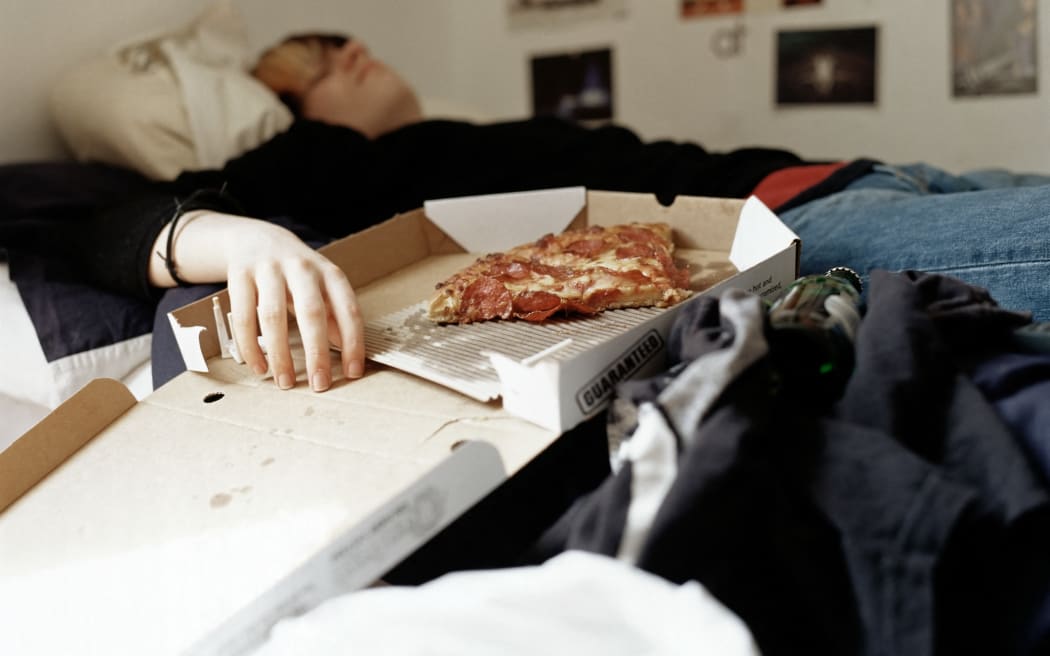Boy sleeping with pizza on bed (Photo by Alys Tomlinson / Image Source / Image Source via AFP)