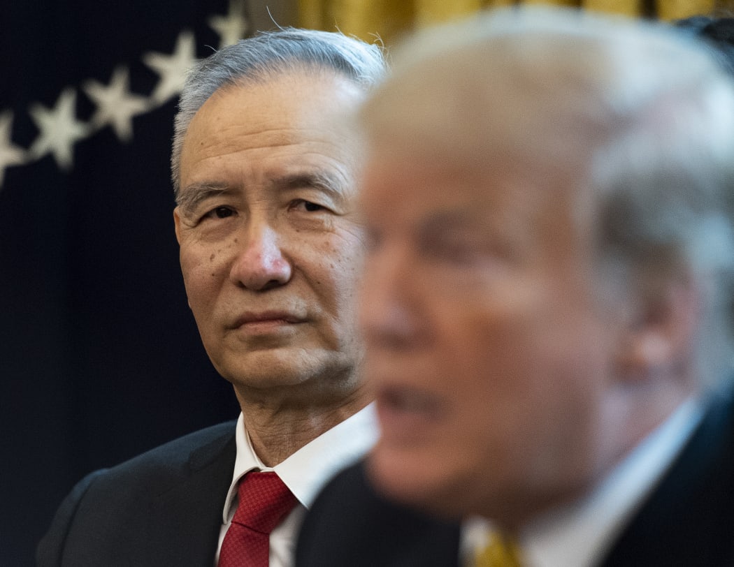 China's Vice Premier Liu He looks on as US President Donald Trump speaks.