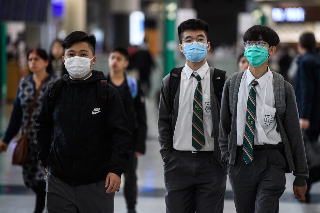 Young students wear face masks in the arrivals hall at Hong Kong's international airport on January 22, 2020.