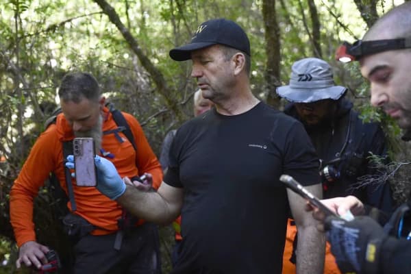 Ken Gamble holding Ms Cremer's phone after it was found by a volunteer who was part of the private search in December.