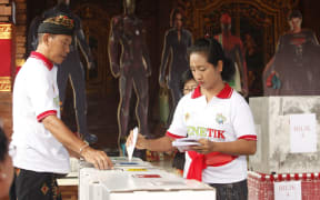A woman casts her ballot at a polling station during election in Bali, Indonesia on Wednesday, April 17, 2019.