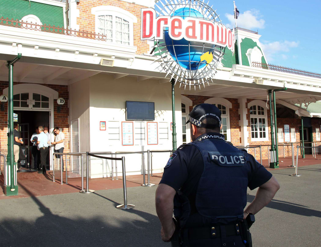 A police officer stands in front of the Dreamworld theme park on Gold Coast after the deaths of four people on a rapids ride.