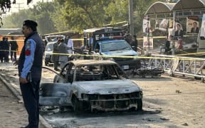 Policemen examine damaged vehicles after a suicide blast outside the district court in Islamabad on 11 November, 2025.