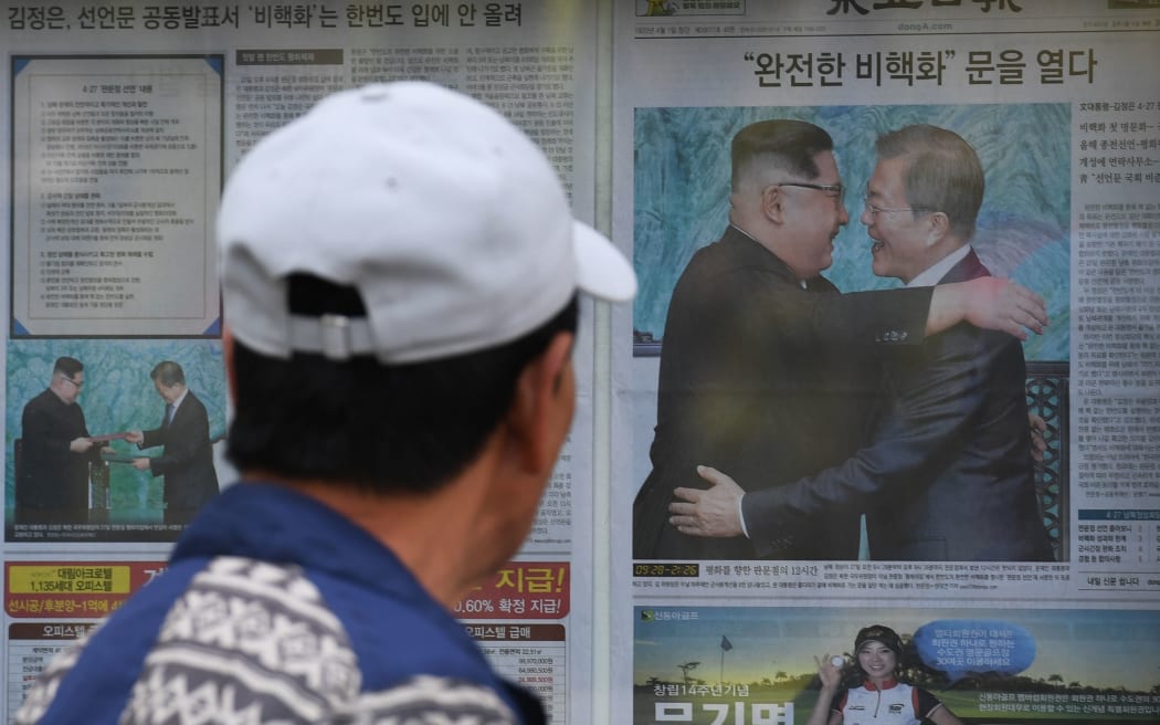 A man walks past a newspaper featuring a front page story about the summit between South Korean President Moon Jae-in and North Korean leader Kim Jong Un