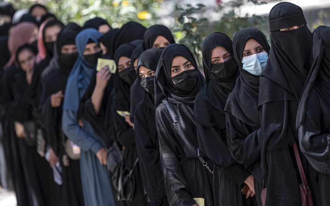 Afghan female students stand in a queue after arriving for entrance exams at Kabul University on 13 October, 2022.