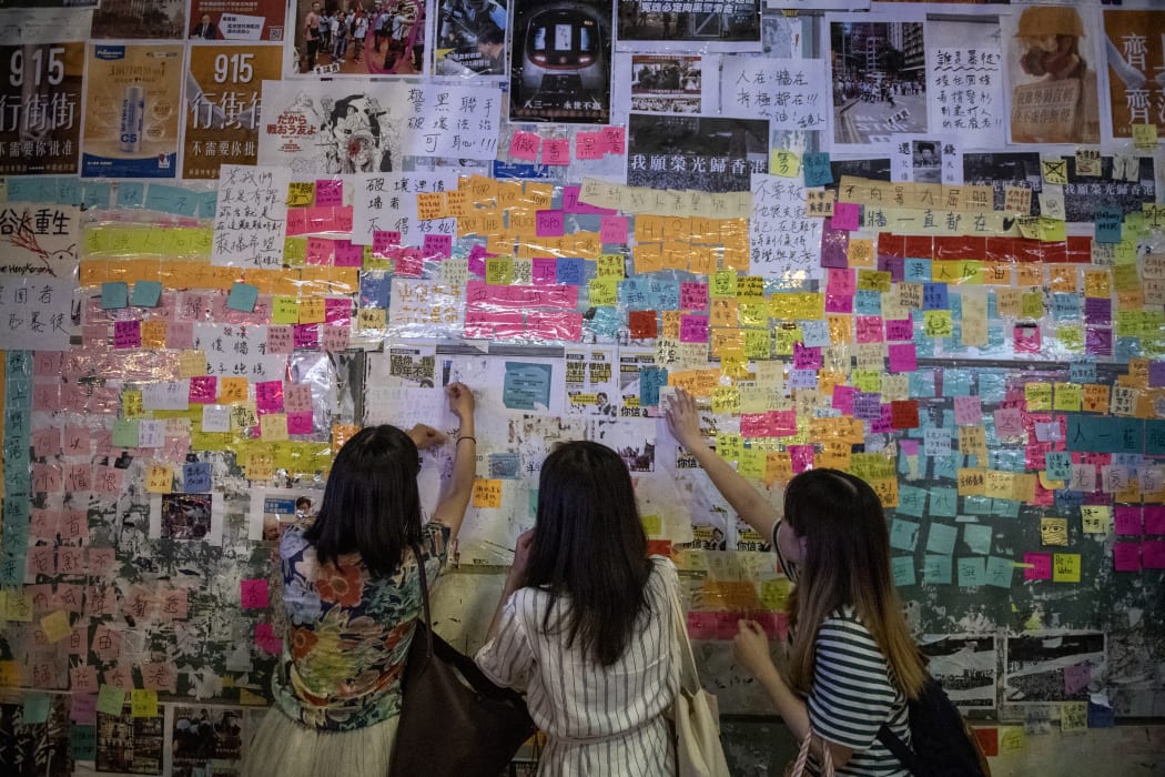 People put stickers with messages in support of the pro-democracy protests on a "Lennon Wall" in Hong Kong on September 16, 2019.