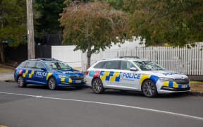 Police are present at a location in Mt Albert where a person is believed to have died in unknown circumstances. A body lays in the gutter on the other side of the black van.