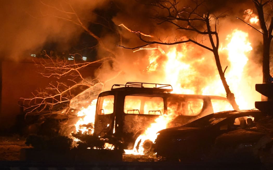 QUETTA,PAKISTAN-APRIL21: Law enforcers examining the scene after an bomb explosion as flames rise at Sereena Hotel in Quetta, Pakistan April21,202 .