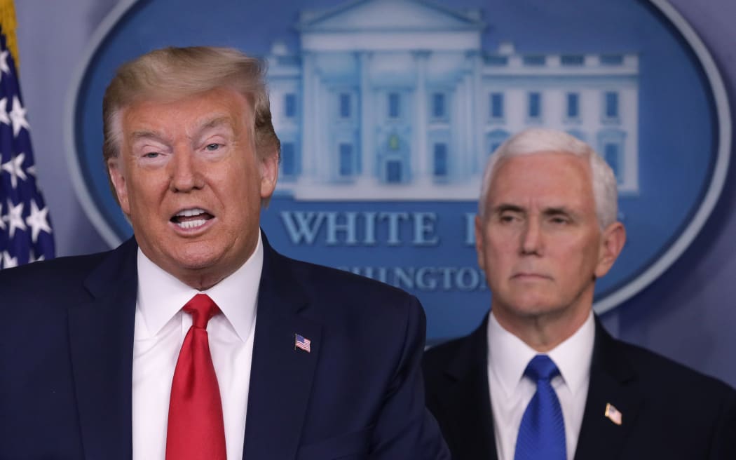 President Donald Trump is flanked by Vice President Mike Pence while speaking during a news briefing on the latest development of the coronavirus outbreak in the US at the White House on 18 March.