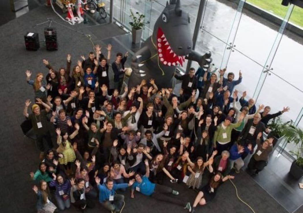 A group of young people look up at photographer on stairs at Auckland's University Business School