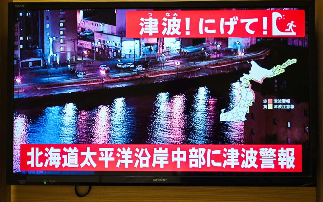 An advisory reading "Tsunami! Run!" (top) and "Tsunami warning issued for central Hokkaido’s Pacific Coast" flashes over the live footage on a television screen in Sapporo, in Japan’s northern Hokkaido prefecture.