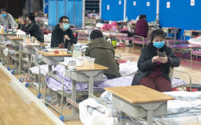 Patients rest at a makeshift hospital in Wuchang District of Wuhan, central China's Hubei Province, March 8, 2020. Patient numbers decreased as many are transferred or discharged. By Sunday afternoon, the hospital has admitted a total of 1124 patients. 116 of them are currently being treated.