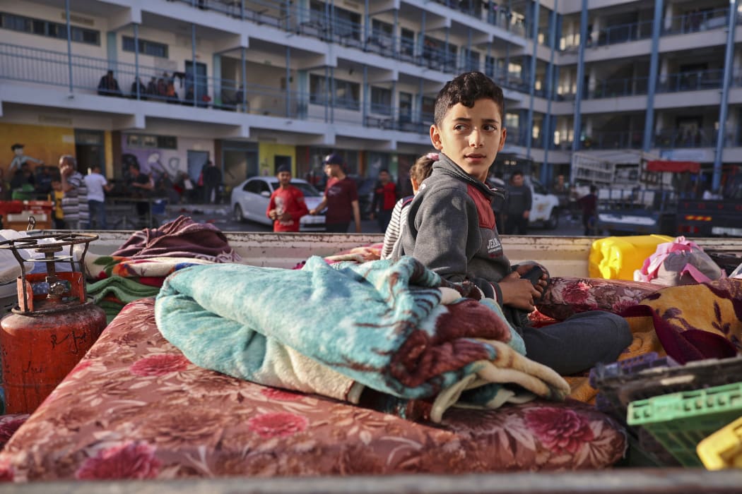 A Palestinian boy who fled his home due to Israeli air and artillery strikes sits on a mattress at a school hosting refugees in Gaza city yesterday.