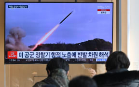 People watch a television screen showing a news broadcast with file footage of a North Korean missile test, at a railway station in Seoul on January 24, 2024. North Korea fired several cruise missiles towards the Yellow Sea on January 24, Seoul's military said, the latest in a series of tension-raising moves by the nuclear-armed state.