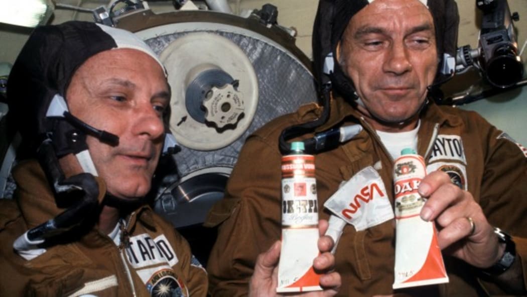 NASA astronauts enjoying fake “vodka” – Russian vodka labels pasted on top of  borscht tubes. Public domain. (not quite beer)
