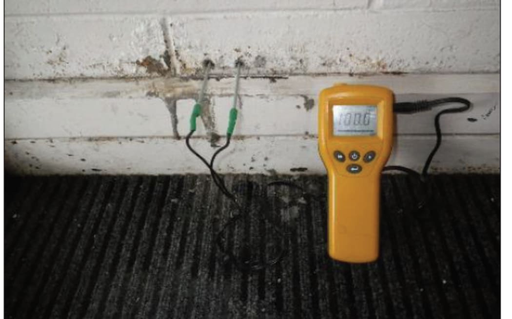 A moistiure meter shows concrete wet at the school.