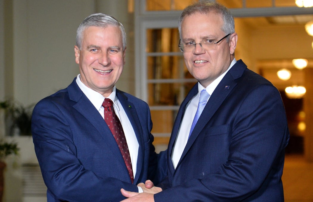 New Australian Prime Minister Scott Morrison (R) shakes hands with Deputy Premier Michael McCormack (L) at the Government House following the prime minister's office oath-taking ceremony in Canberra on August 24, 2018.