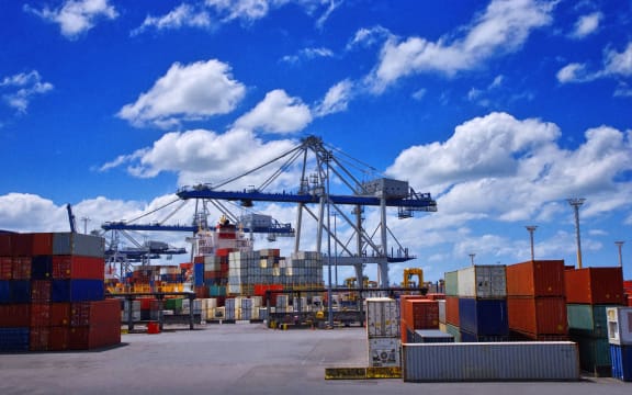 View of colorful containers and cargo cranes in a port.