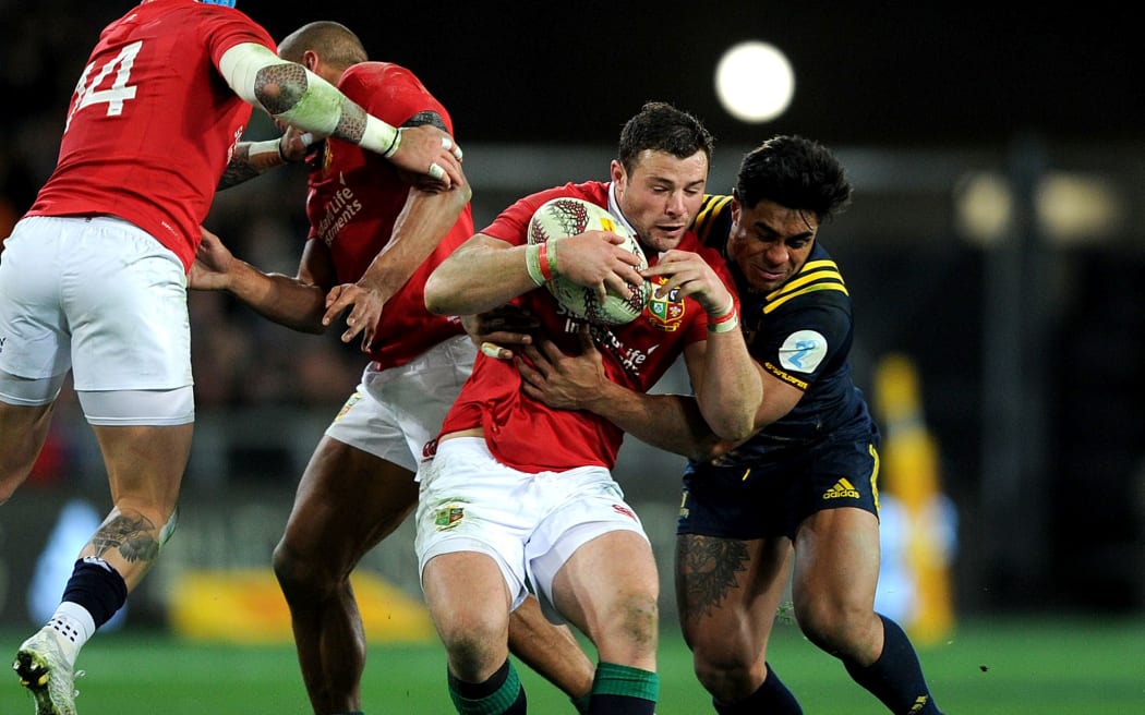 Robbie Henshaw is caught by the defence during The Lions match against the Highlanders.