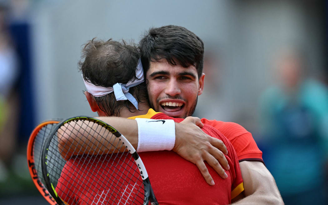 Spain's Carlos Alcaraz (R) and Spain's Rafael Nadal (L) react to beating Netherlands' Tallon Griekspoor and Netherlands' Wesley Koolhof in their men's doubles second round tennis match on Court Suzanne-Lenglen at the Roland-Garros Stadium during the Paris 2024 Olympic Games, in Paris on July 30, 2024. (Photo by MARTIN BERNETTI / AFP)