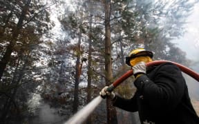 A firefighter hard at work in the Port Hills, Christchurch. Photo taken 18 February 2017.