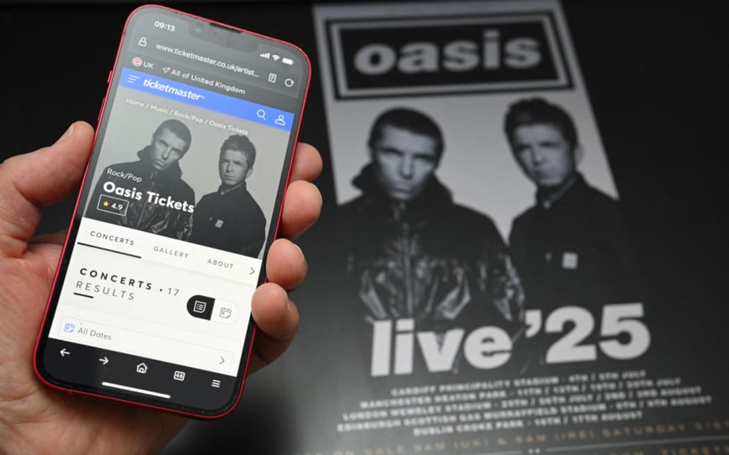 A fan uses a smart phone to access an on-line ticket sales website to purchase tickets for Oasis' "Live '25" tour.