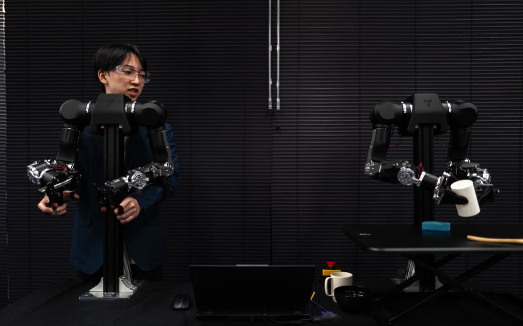 Hiro Yamamoto, CEO of company Enactic,  tele-operating an OpenArm humanoid robotic arm.
