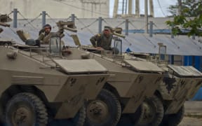 Soldiers remain inside armoured vehicles outside the Guayas 1 Center for the Deprivation of Liberty (Litoral Penitentiary) in Guayaquil, Ecuador, on 13 November, 2021, after a riot occurred. Ferocious clashes have left 68 inmates dead, police said.